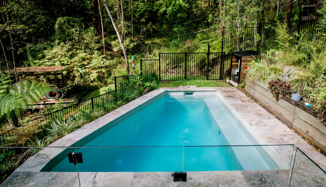 Side on view of curved pool in backyard